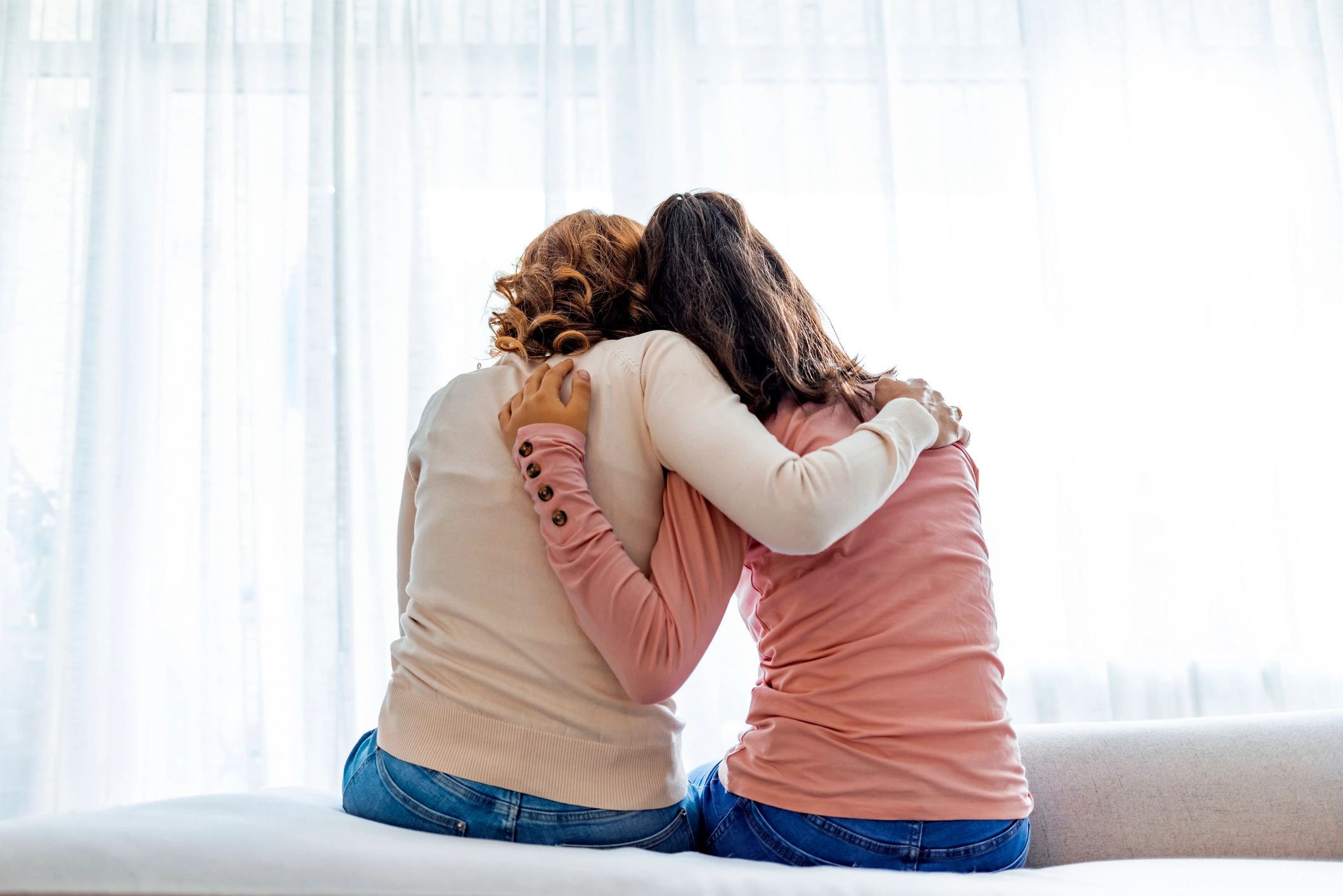 Mother and daughter embracing at home