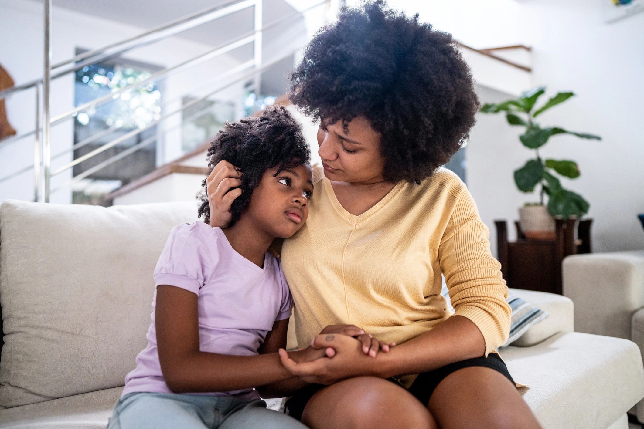 Mother embracing her daughter on a sofa