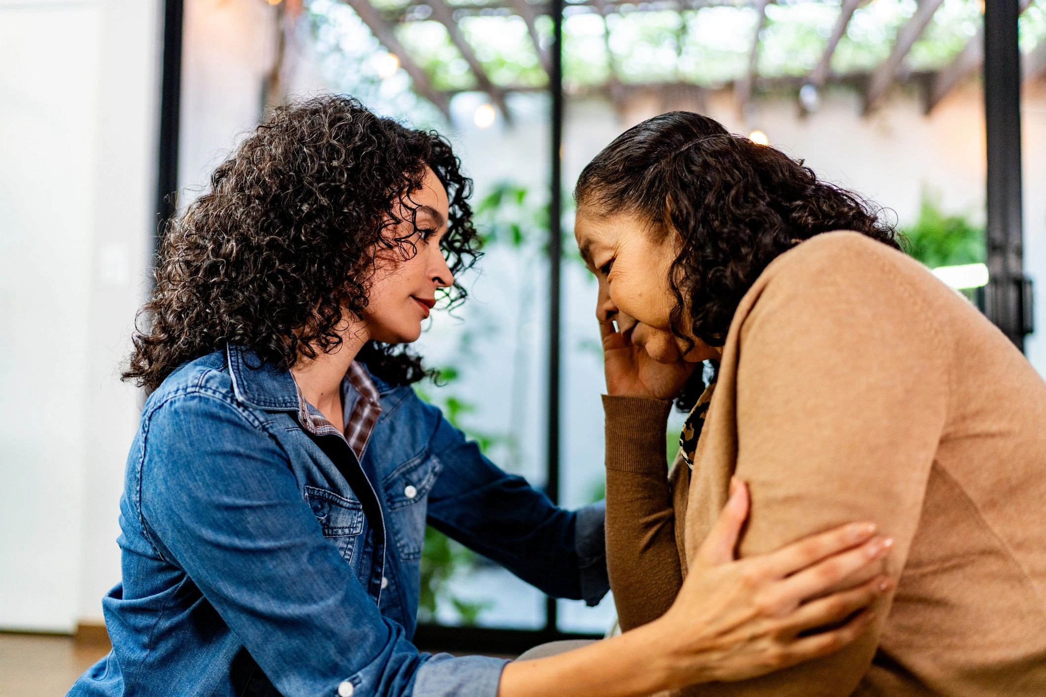 Young woman consoling her mother at home